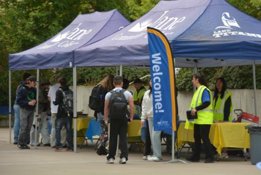 Students gather at Lane Community College welcome tents with staff assisting