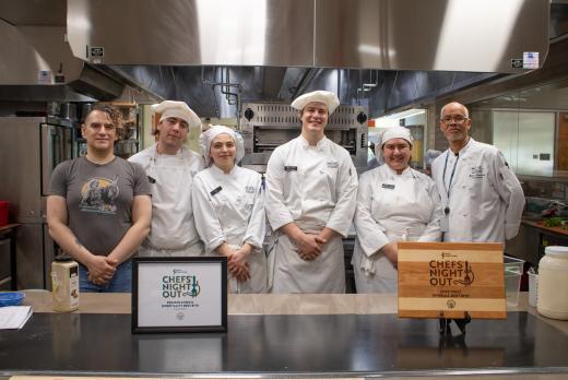 culinary students and their instructor, Chef Michael, smile and pose with their award in the Lane kitchen/classroom