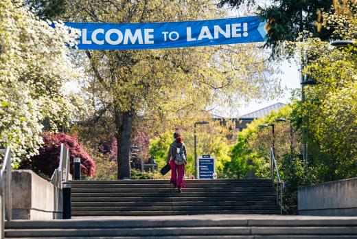 student walking up stairs with welcome side overhead