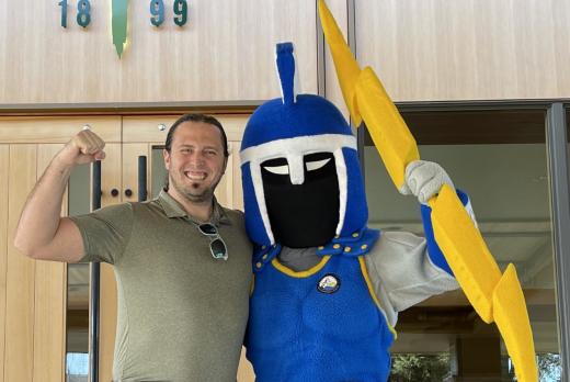 Board Member Austin Folnagy standing with Ty the Titan