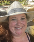 Communications instructor Kendra Rivera smiling and wearing a big sun hat at a zoo