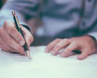 Person writing on a piece of paper