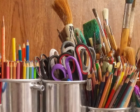 artists work table with brushes, pencils and other tools ready to go for project