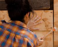 Construction worker hammering board in place