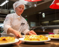 Culinary student placing plates ready for service