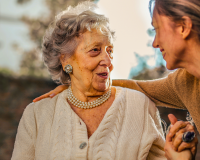 A woman greeting and hugging another woman