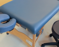 massage table and a stool at a massage school for a massage therapy program