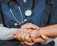 nursing staff holding a patient's hand