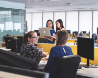 smiling young employees talking and looking at computers