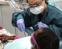 A student in LCC's dental assistant program works with a young patient