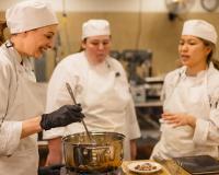 culinary school students laughing and cooking together