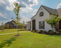 a lovely brick house with a big lawn on a sunny day