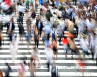 many people crossing a large crosswalk in a city