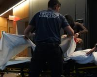 paramedicine students practice lifting a dummy onto a stretcher