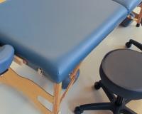 massage table and a stool at a massage school for a massage therapy program
