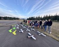 a class of unmanned aircraft students posing with their drones at the Oakridge airport