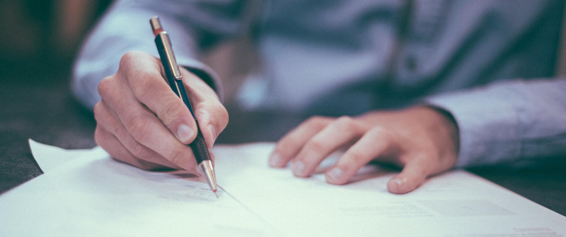 Person writing on a piece of paper