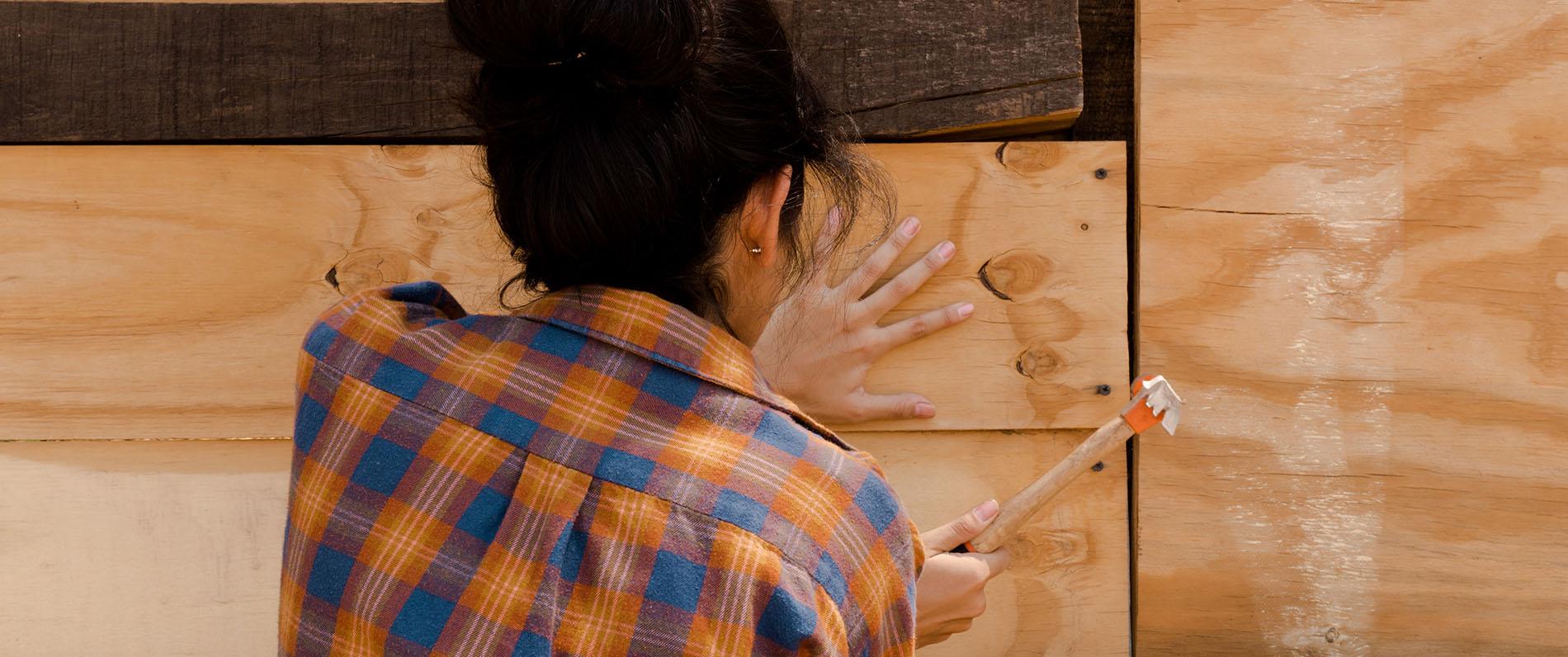 Construction worker hammering board in place