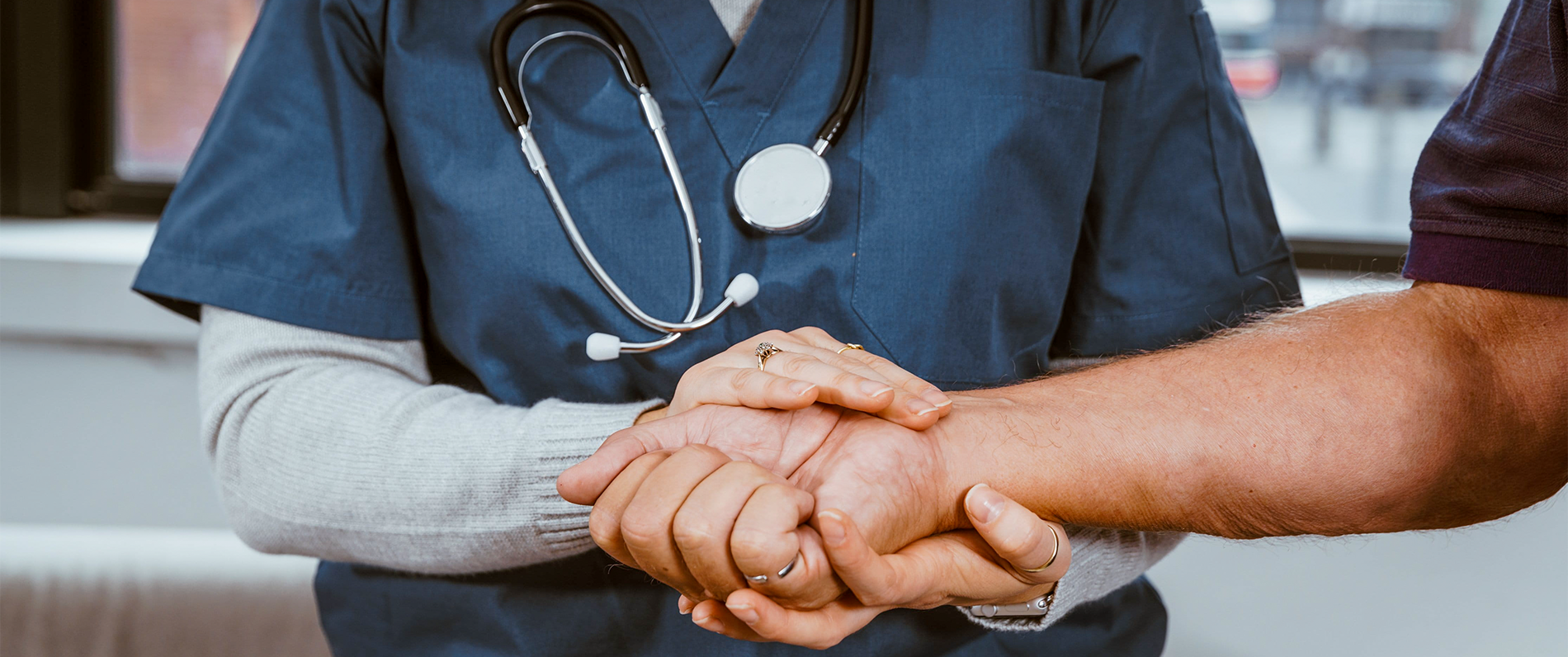 nursing staff holding a patient's hand