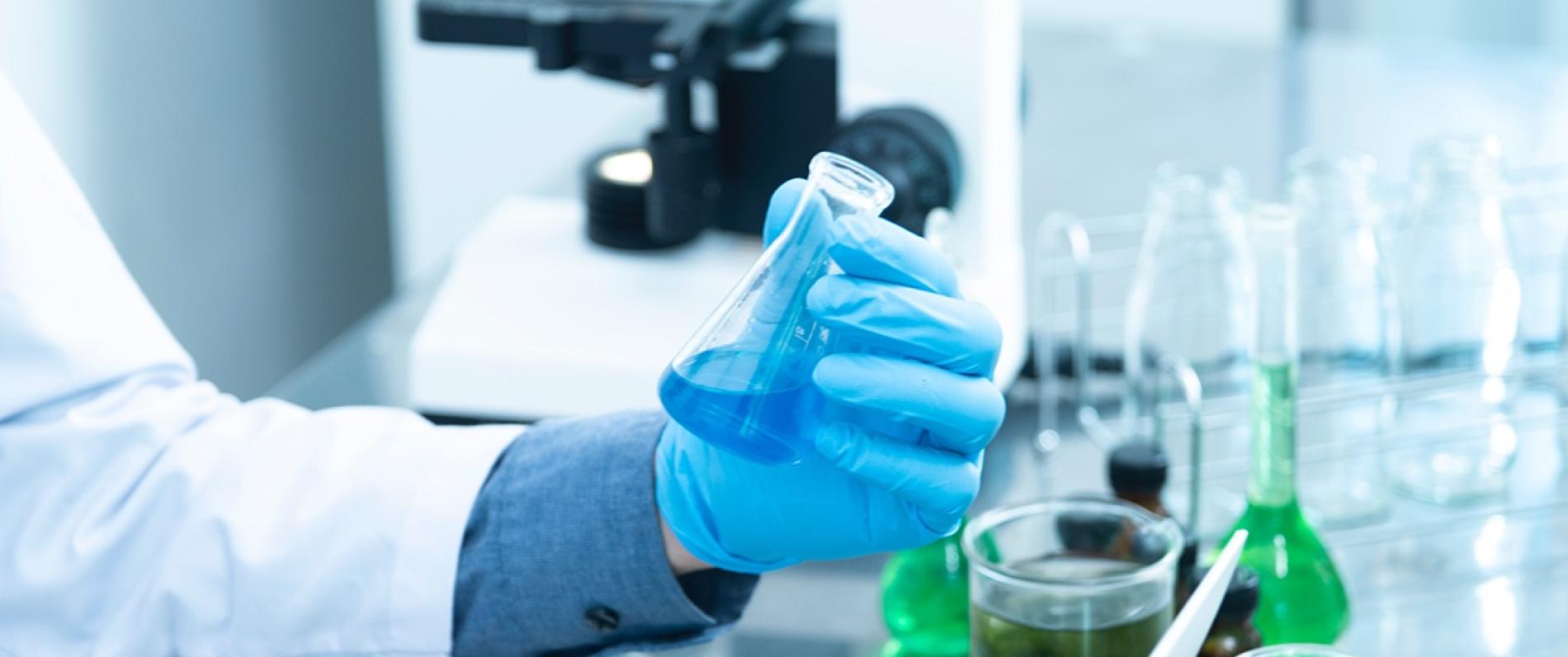 person in chemistry lab holding a beaker