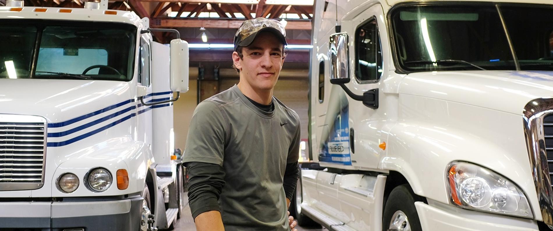 man between two white trucks