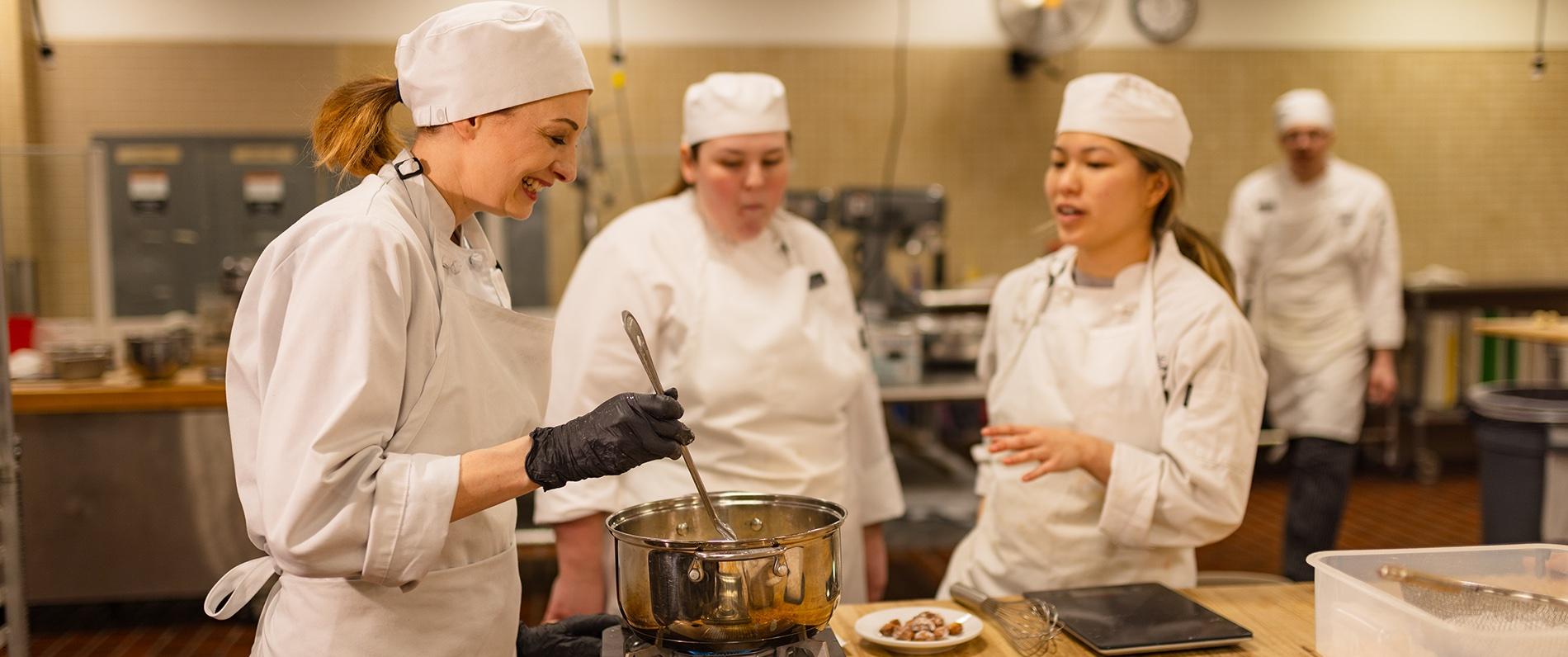 culinary school students laughing and cooking together