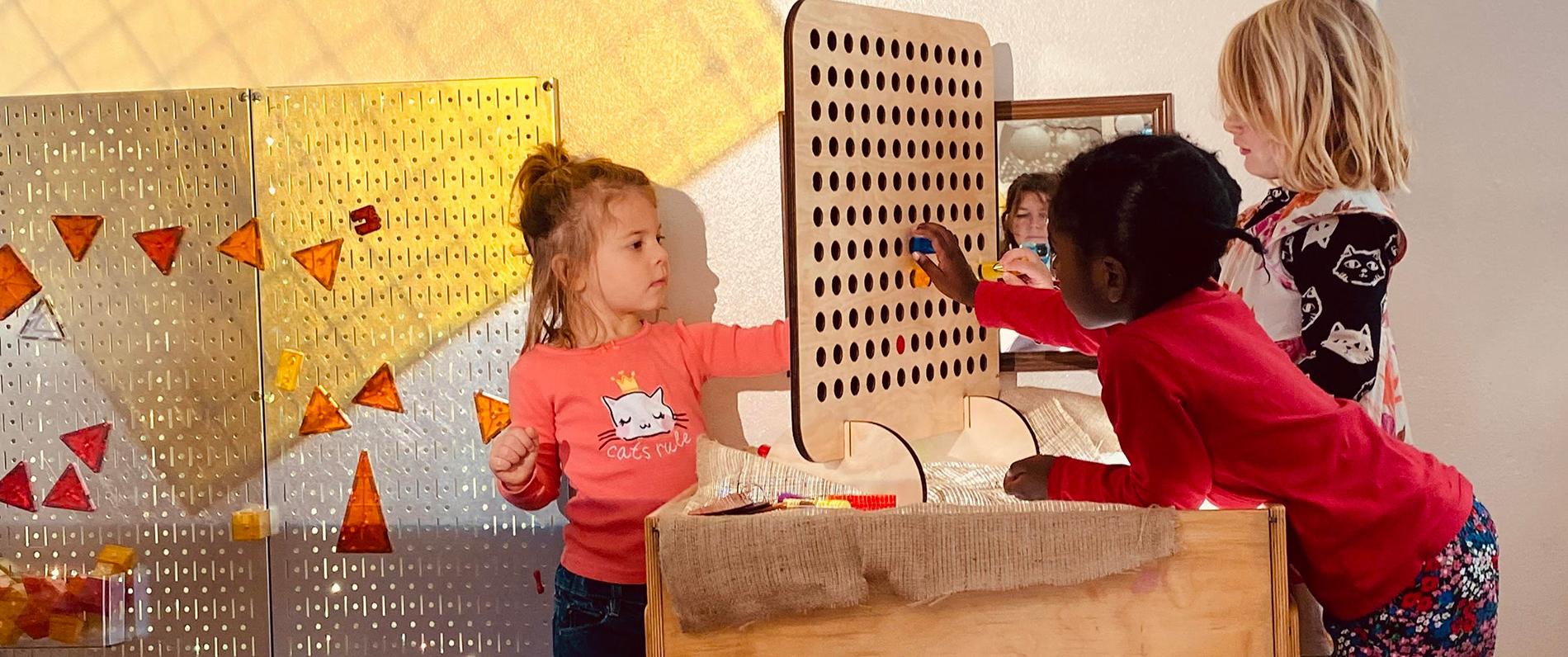 children playing with a pegboard as part of the early childhood education program