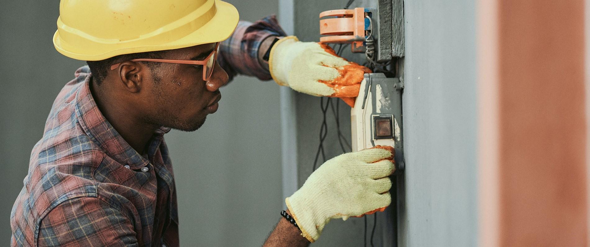 an electrician apprentice with a hard hat working