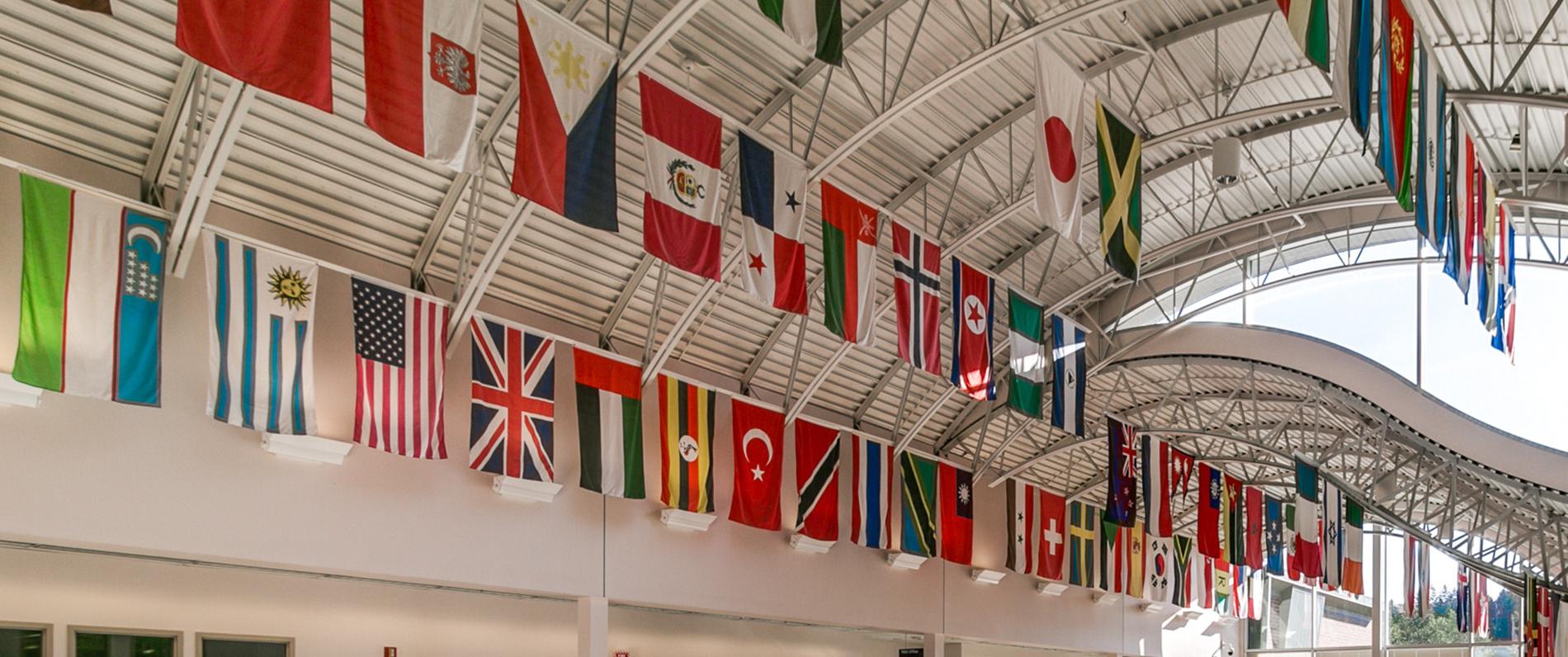 flags from around the world displayed on the sunny ceiling of Building 1 at LCC