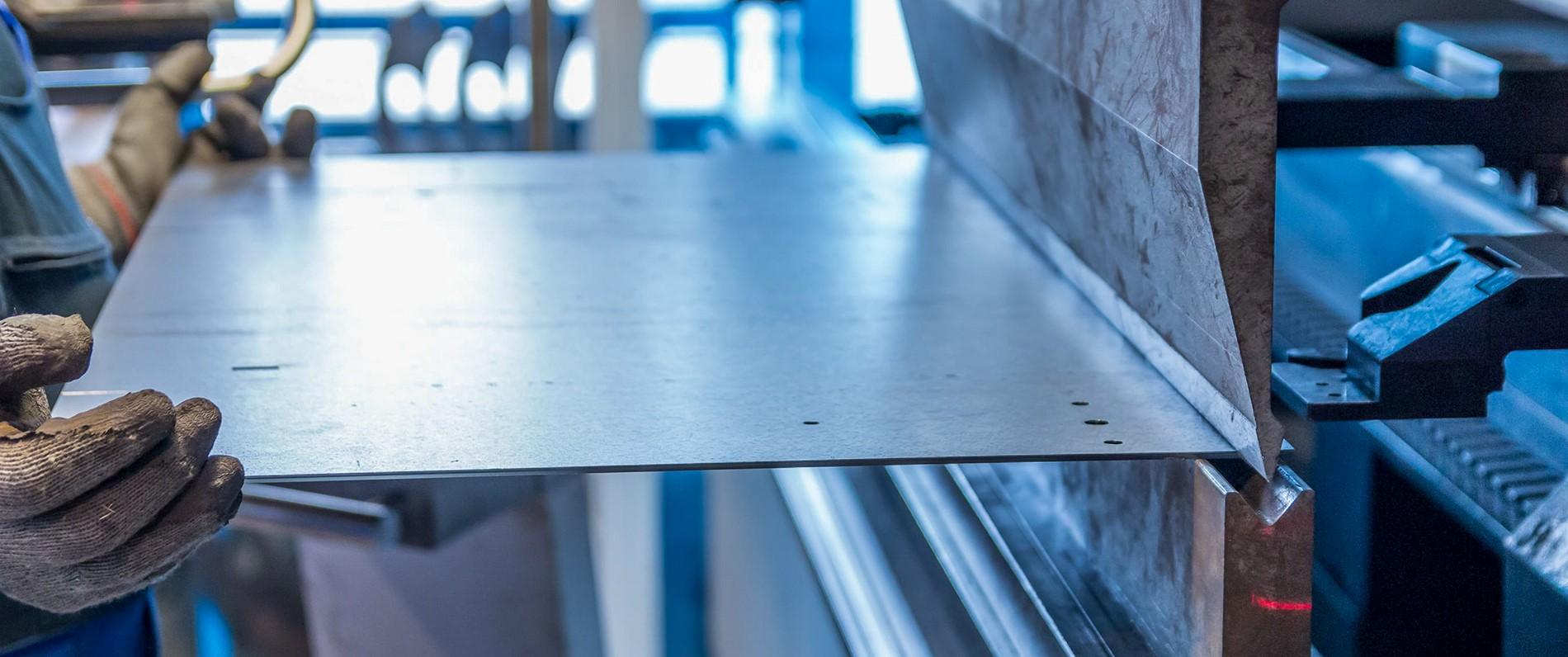 a sheet metal apprentice works with sheet metal and a machine