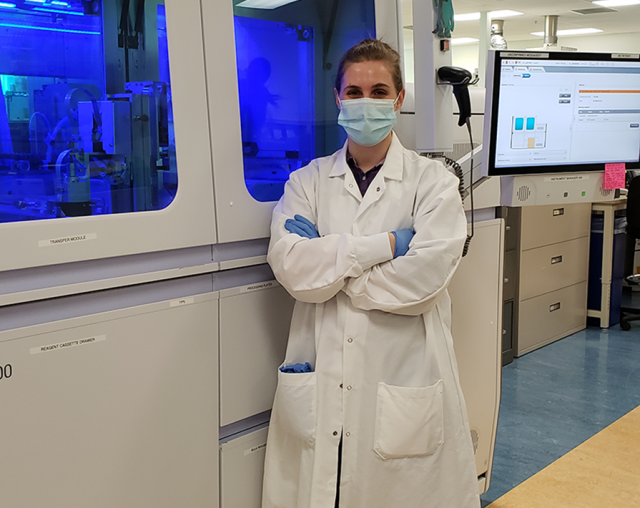 A science student proudly standing in a lab