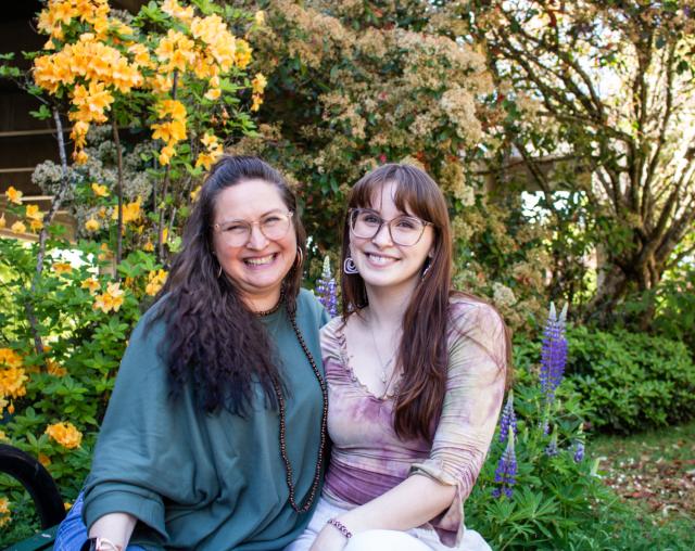 Aya & Emma Lyddon smiling together with flowers in background