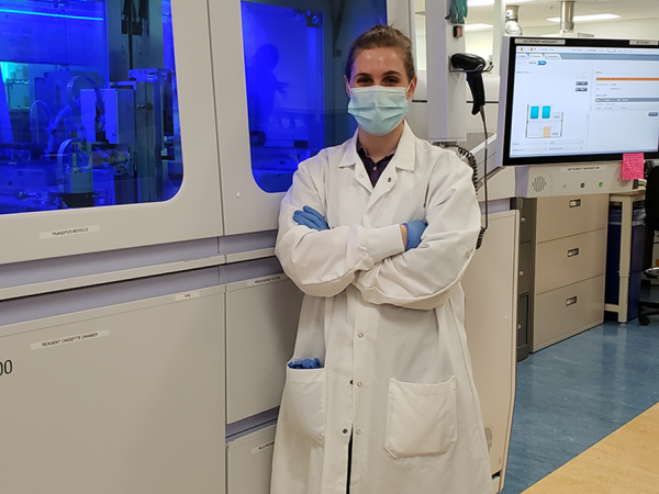 A science student proudly standing in a lab