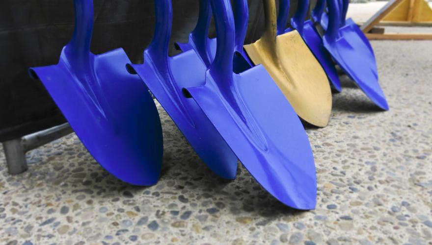 a group of blue shovels and one bronze shovel