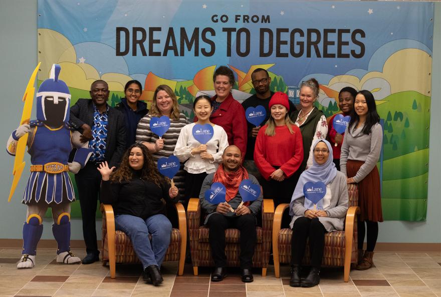 The international programs team, in front of a sign which says From Dreams to Degrees