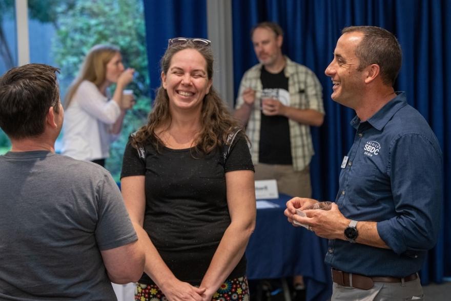 Dan Collins, the director of Lane SBDC laughs with a business client at a showcase