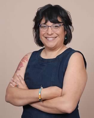 Longhouse Steward Cohen-Rencountre, a Native American woman with a friendly smile, glasses, and an upper arm tattoo