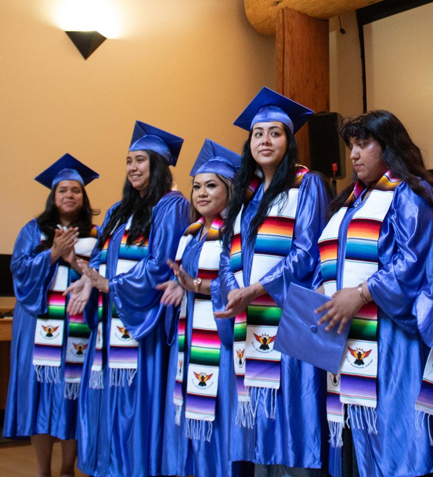 a group of young Latina women wearing proudly wearing blue graduation caps and gowns and MECHA serape stoles
