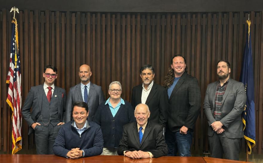 Lane's board, in the boardroom, between an American flag and the state of Oregon flag. The chair and vice-chair are sitting.