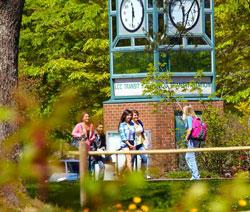 students by clock tower at main campus bus station