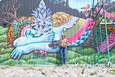 Ila Rose with her first public mural in the Whiteaker at 5th Alley and Blair Boulevard. Photo by…