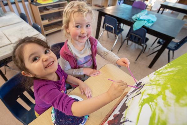 students paint on a canvas together