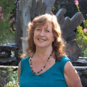College Achievement Coach Fiora Starchild-Wolf, a friendly older woman with a turquoise shirt and necklace
