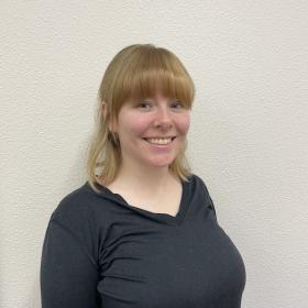 Emily Rudzitis, a blonde young woman with long bangs and a big smile