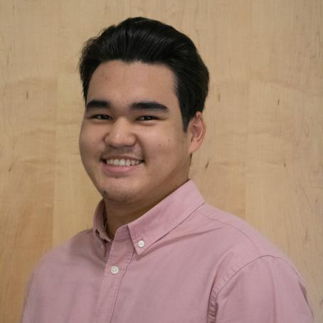A young man of Central Asian descent smiling