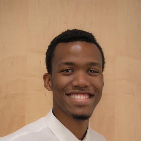 A tall young Black man with a friendly smile