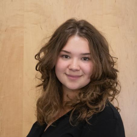 Sophie Gibson, a young woman with curly brown hair and a big smile