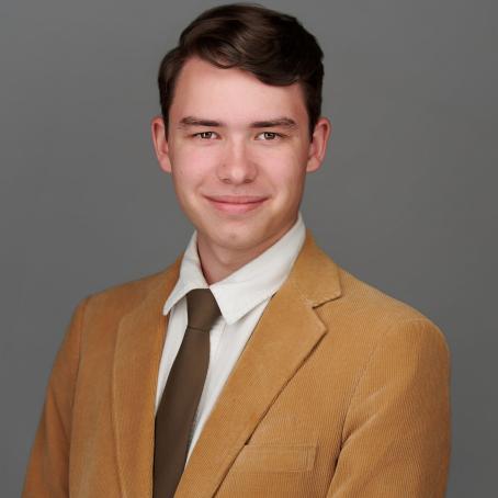 Michael Olson, wearing a tan suit and tie