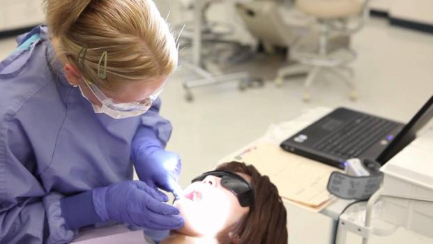 Dental Hygiene student in clinic with patient