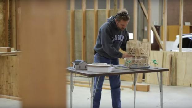 a construction technology student looks at an architecture model in a workshop